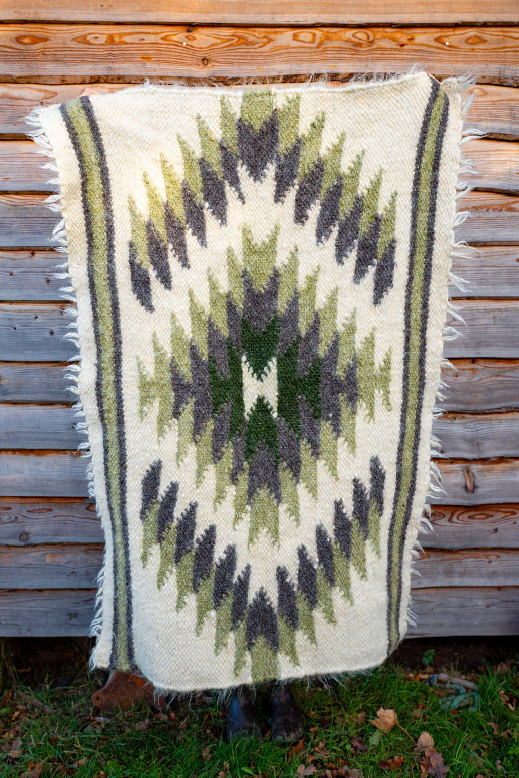 Handwoven wool rug with green diamonds.